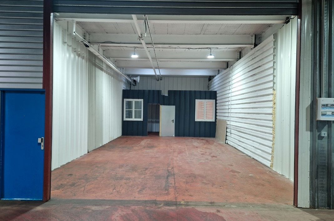 Atelier de 82 m² vu depuis la porte sectionnelle, hauteur sous plafond 4,50 m